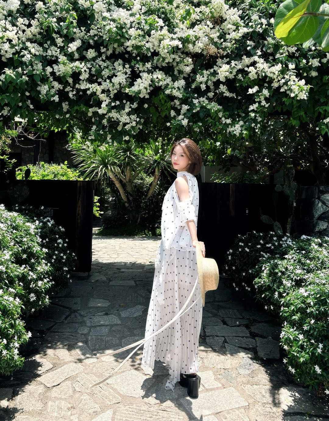 Woman in a white dress in a sunlit garden
